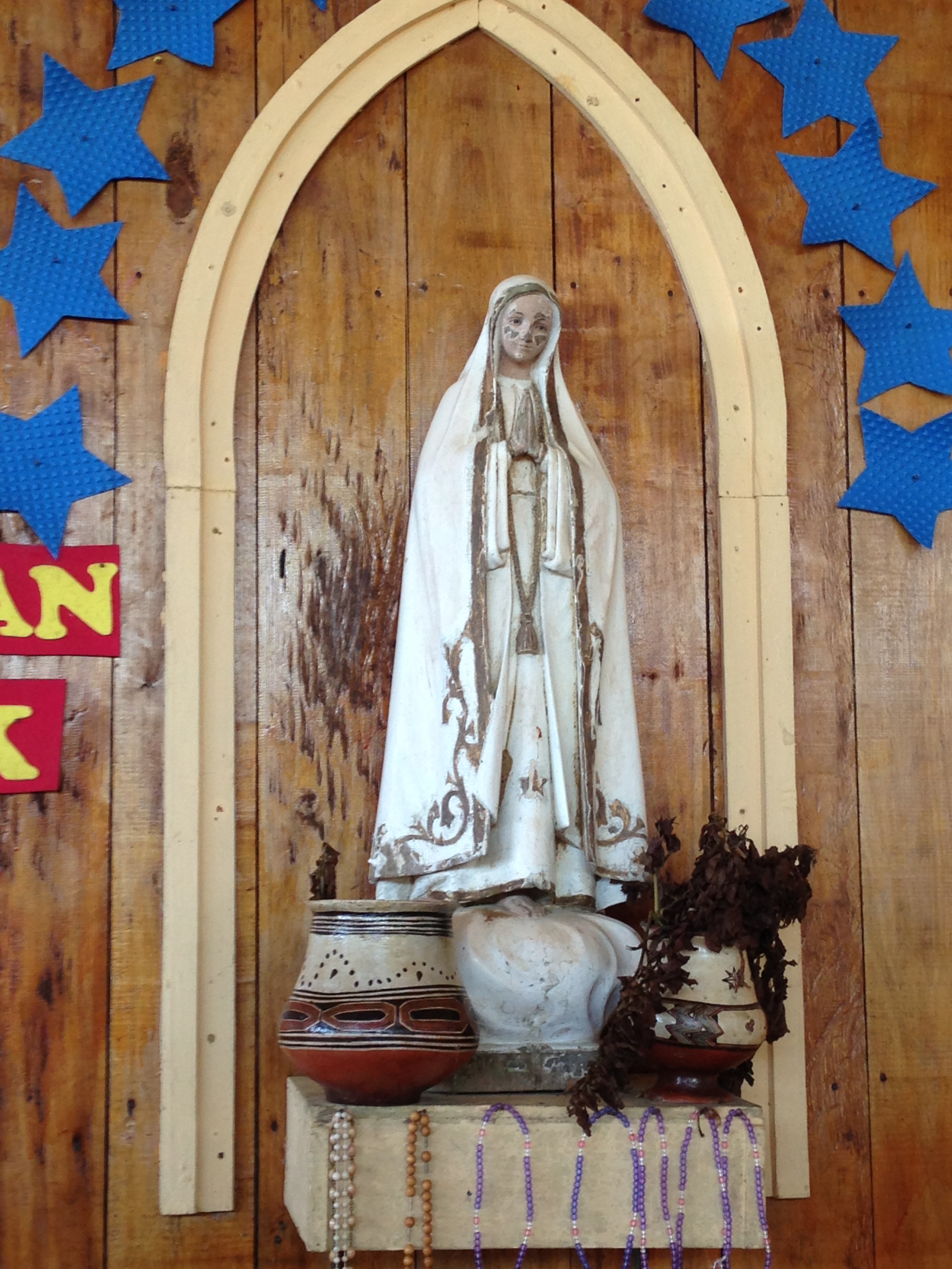 Virgin Mary statue with tinaja and rosaries